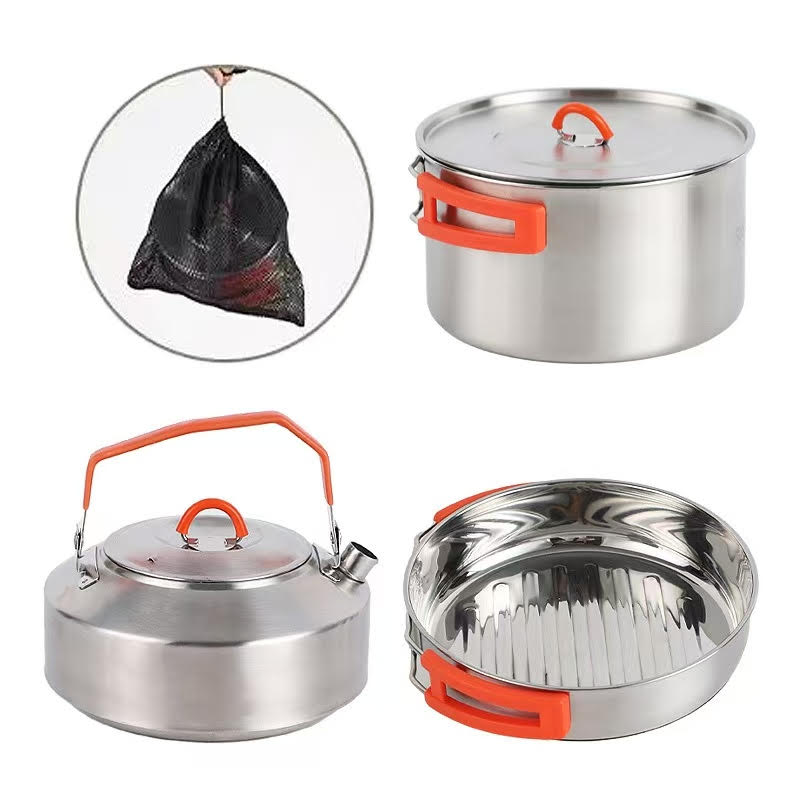 Set of stainless steel cookware with orange handles on a white background